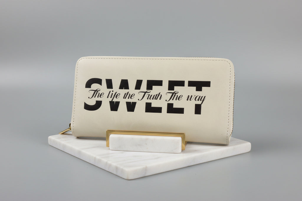Beige wallet with black text on a gray background