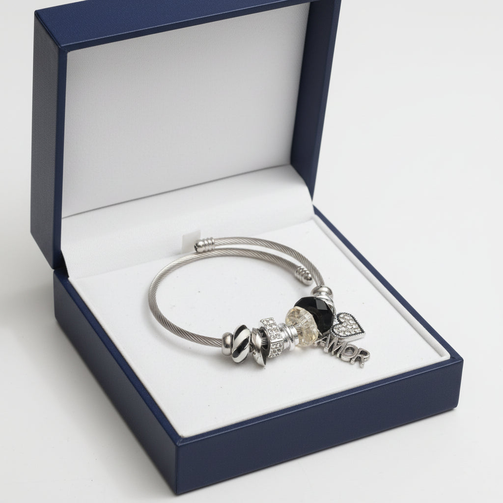 Silver bracelet with various charms on a white background