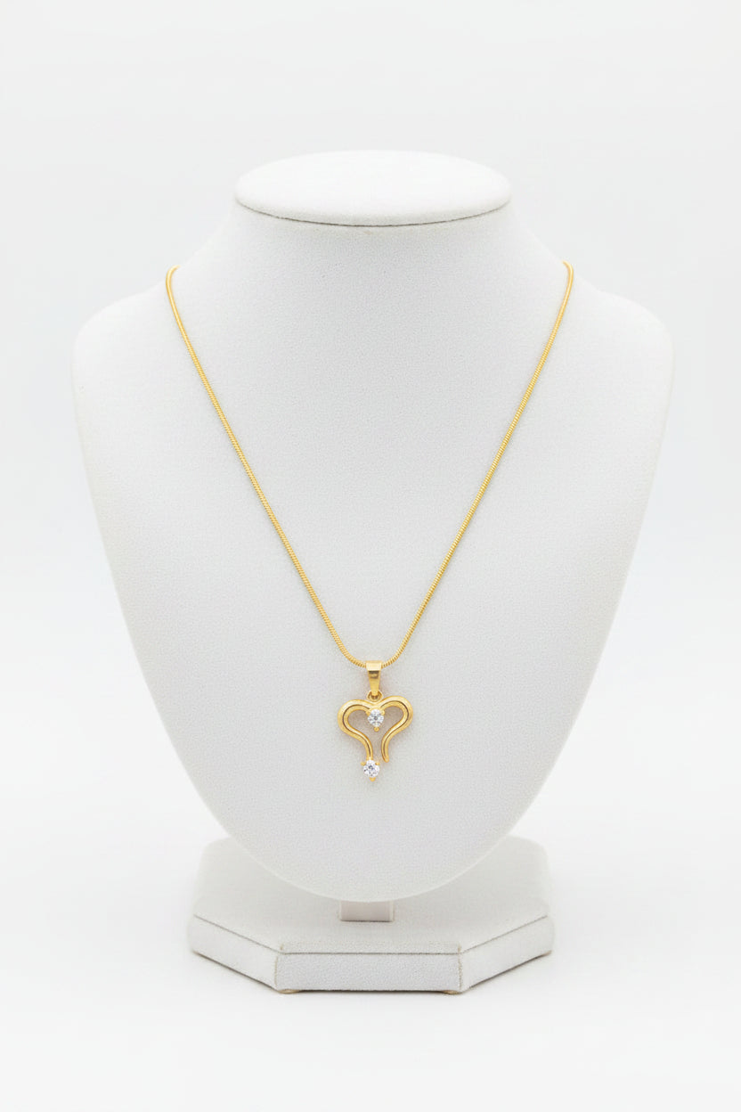 Gold necklace with a heart-shaped pendant on a white background
